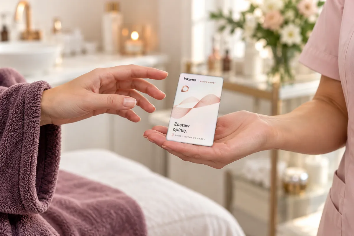 Kosmetyczka podaje na otwartej dłoni kartę NFC Lokamo klientce w szlafroku, która sięga po nią ręką.